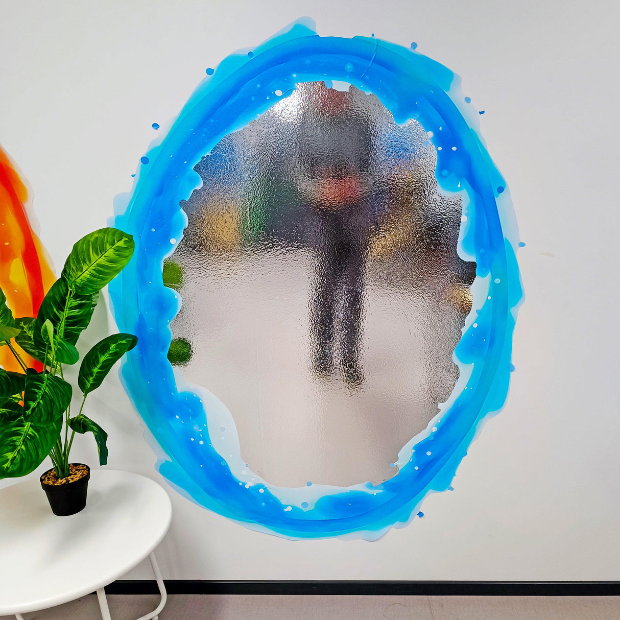 Blue and orange oval portal aura wall sticker on a wall, creating a vibrant decorative effect for game rooms.