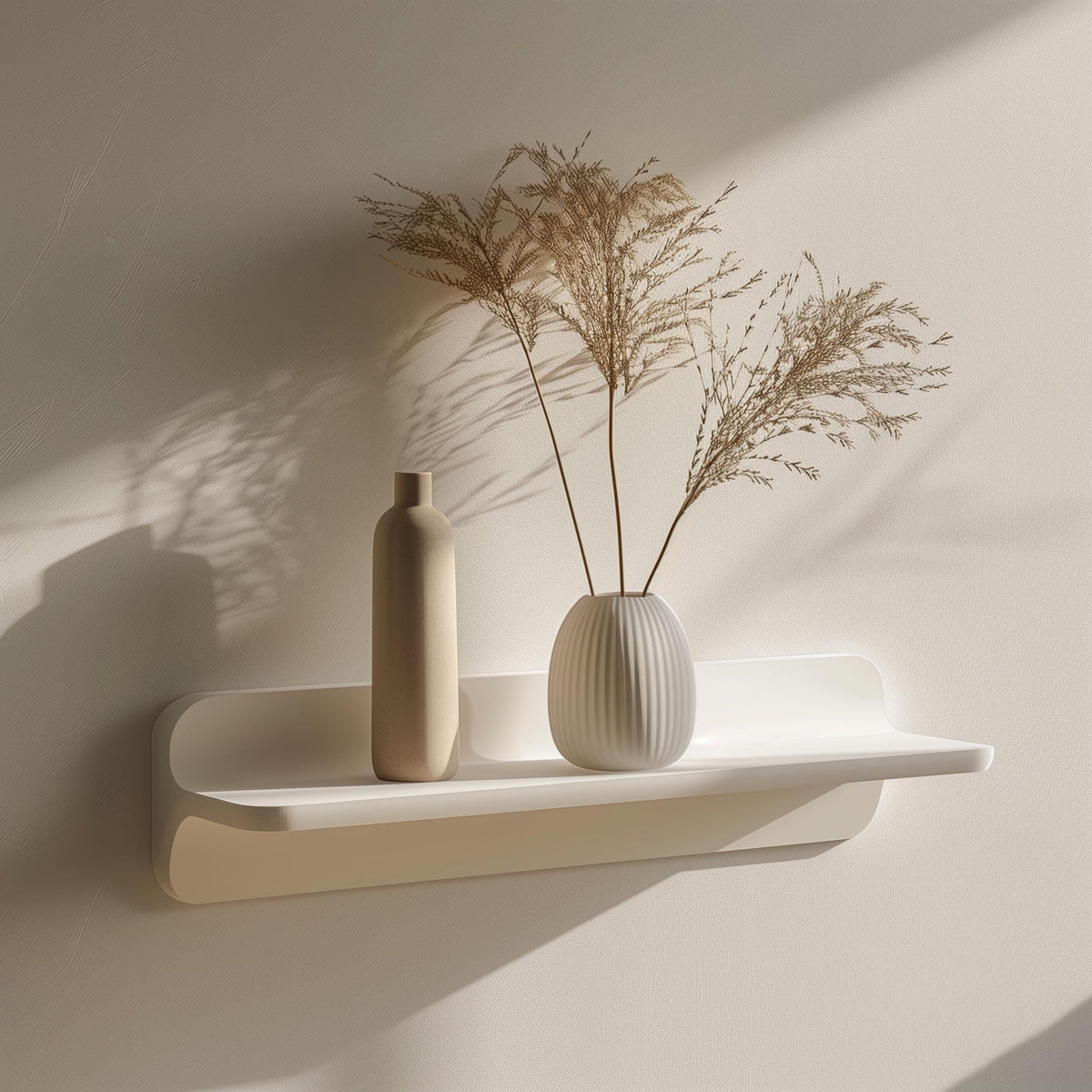 Minimalist 3D printed wall shelf in matte white, holding decorative vases and dried plants.