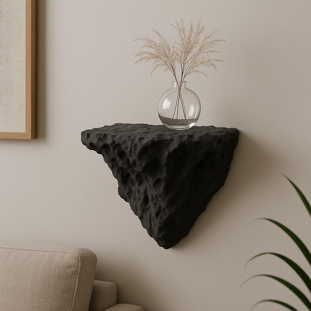 A black 3D printed wall-mounted shelf with a rugged, rock-like texture and triangular shape.
