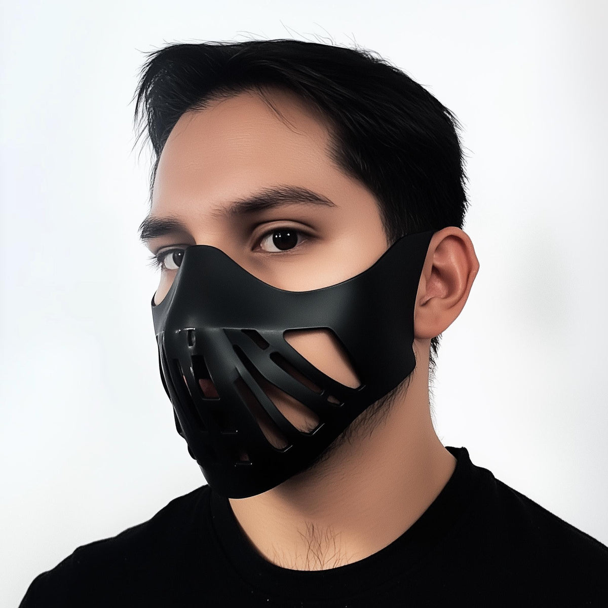 Side profile view of a man wearing a black 3D printed half face mask with angular cutouts.