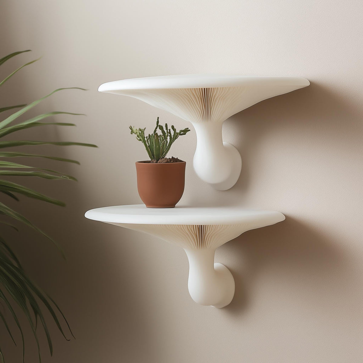 Pair of white 3D printed mushroom-inspired wall shelves mounted on a neutral wall, styled with a terracotta potted cactus.