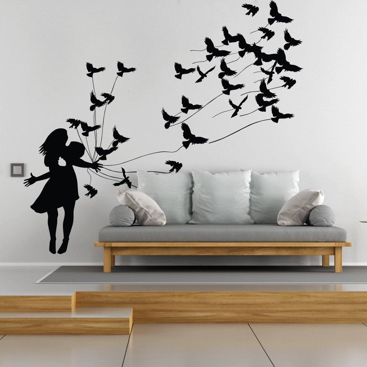Girl silhouette wall sticker releasing birds above a modern sofa.