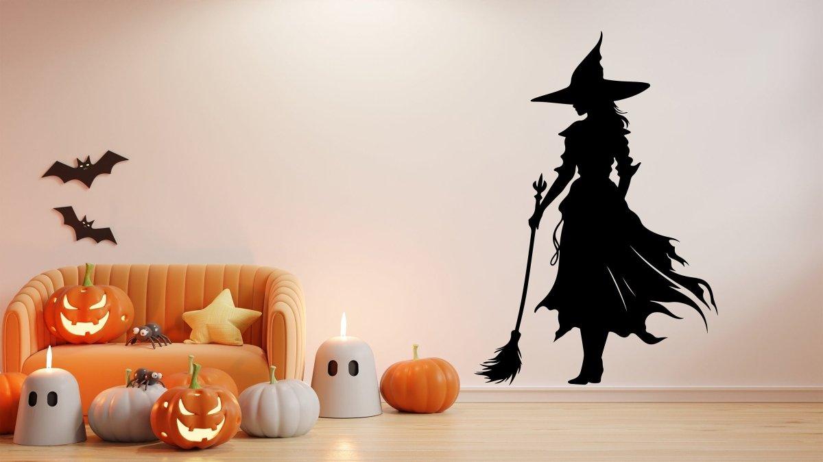 Witch silhouette decal on wall with pumpkins and Halloween decor.
