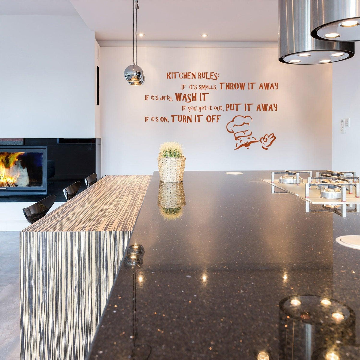 Family kitchen wall sticker with humorous rules on a white wall above a modern countertop and fireplace.