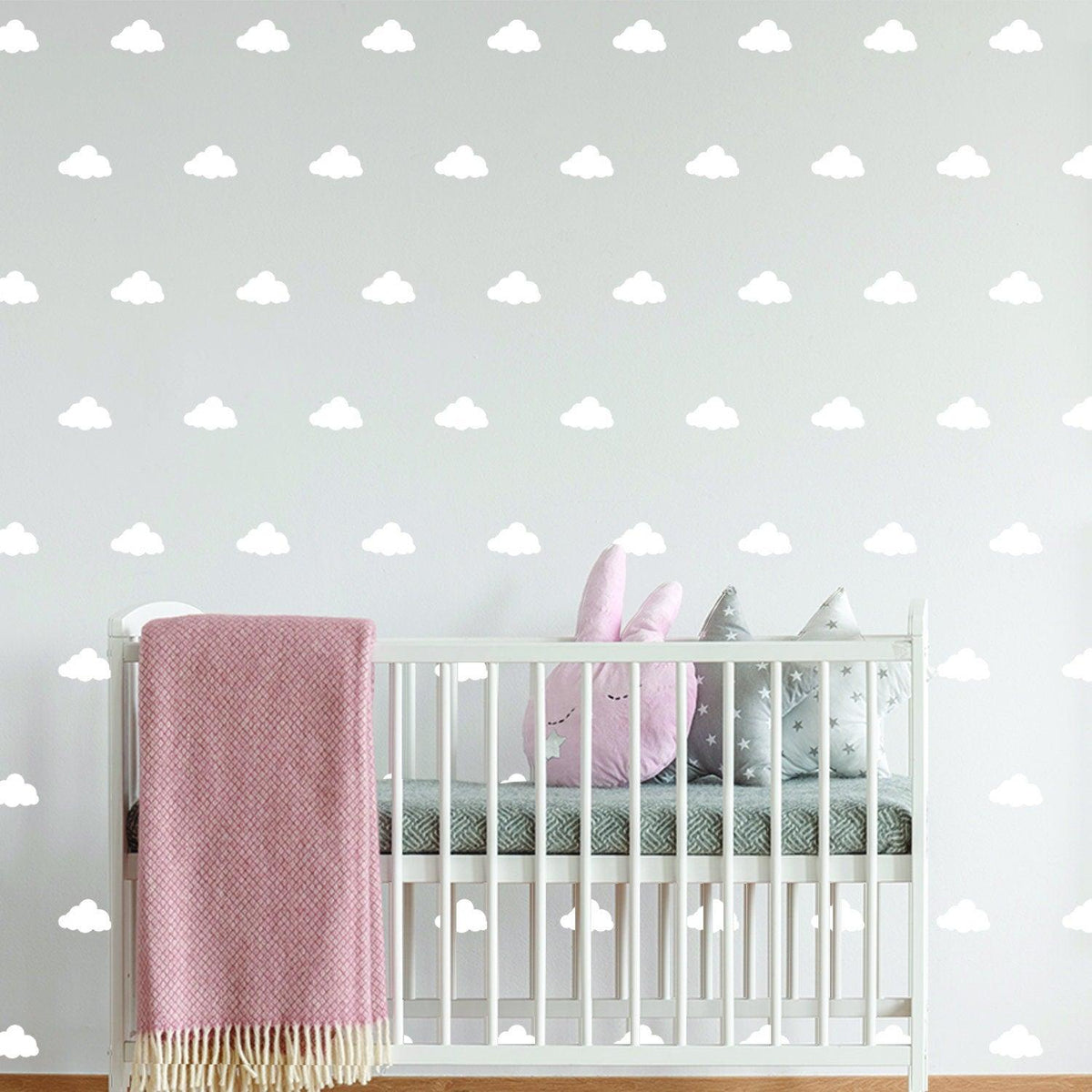 40 cloud wall decals in a nursery above a crib, creating a whimsical and serene baby room atmosphere.