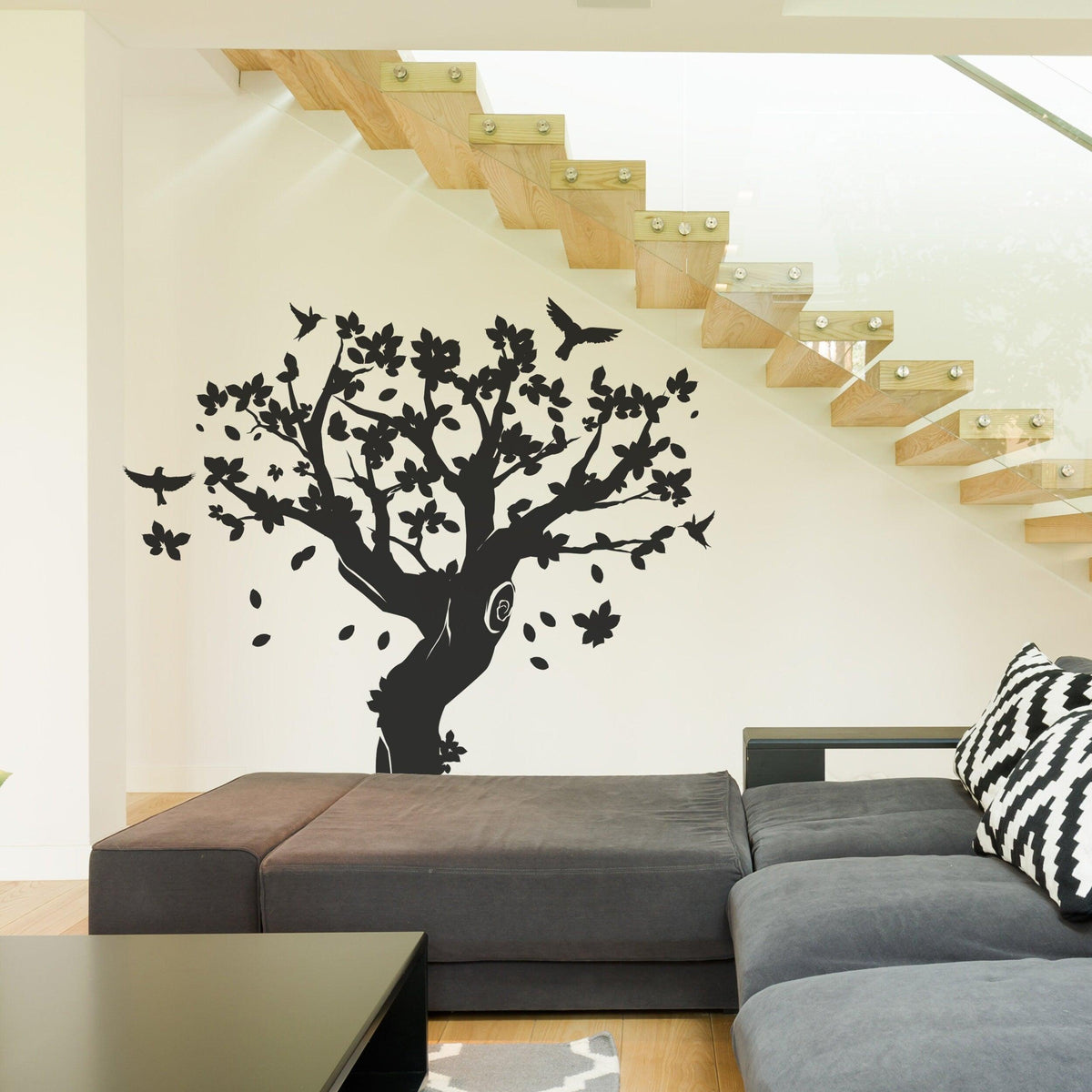 Black tree wall decal with birds and flowers in a modern living space.
