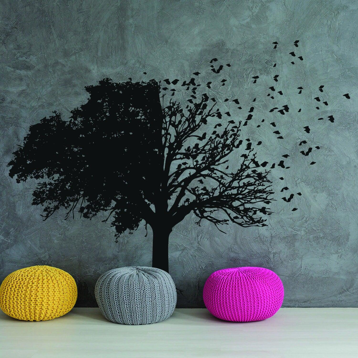 Tree wall decal decor with birds and branches above colorful poufs in a stylish interior.