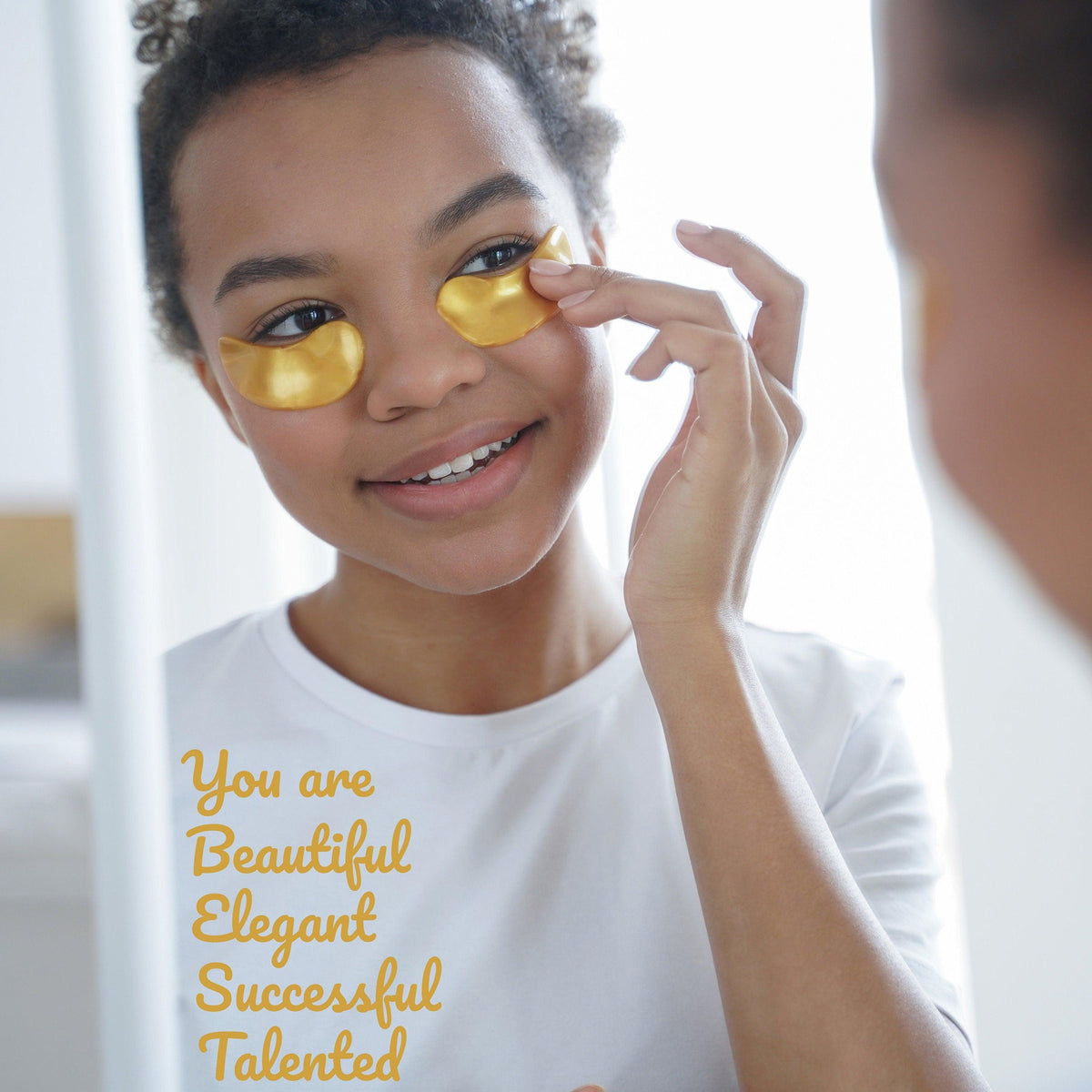 Girl applying gold eye gel patches with motivational affirmations in the mirror, promoting self-love and positivity.