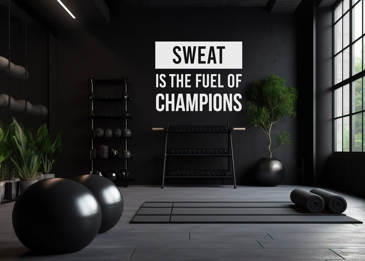 Gym interior with motivational wall decal 'Sweat is the Fuel of Champions' and weights.