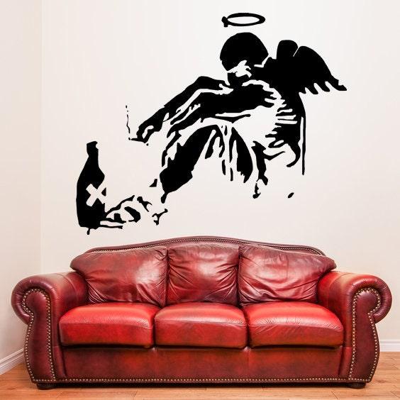 Fallen angel wall sticker above a red leather sofa.