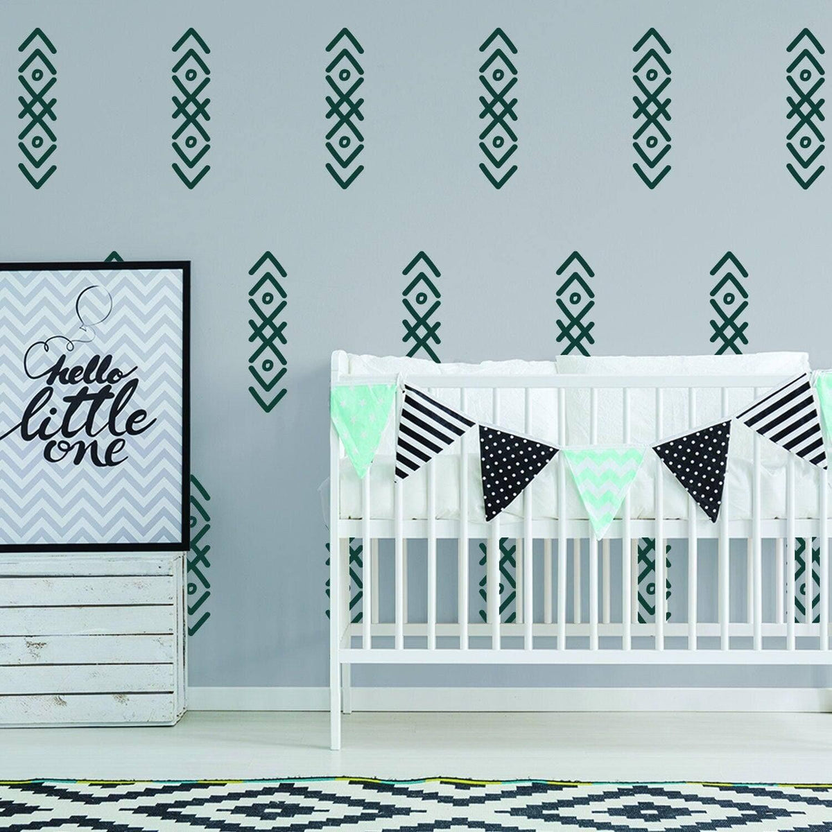 WhimsyArrows vinyl wall decals on nursery wall, crib with decorative bunting, and framed art.