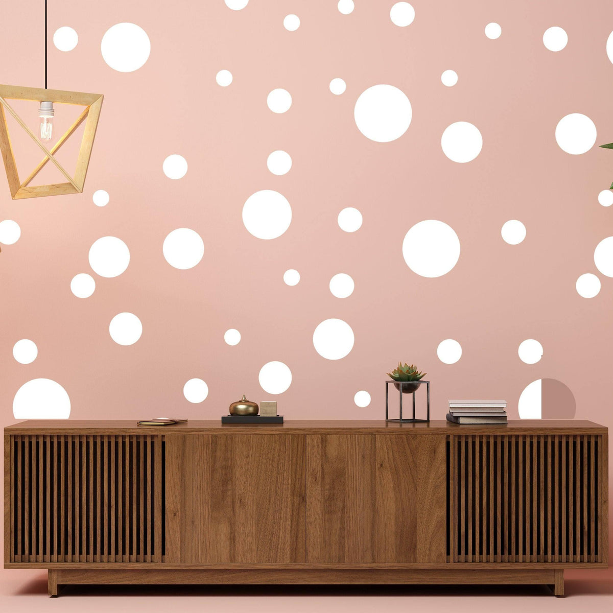 Adhesive white round dot stickers on a pink wall with wooden cabinet, adding a creative decor touch.