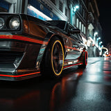 Close-up of a sleek car with vibrant orange geometric decals on wet street, showcasing a modern and stylish vehicle design.