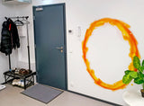 Vibrant orange portal aura wall sticker adoring a modern entrance, enhancing game room decor with a dynamic look.