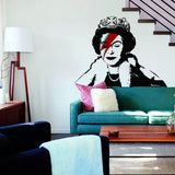 Яркая наклейка с коронованной фигурой на стене гостиной.