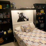 Contemplative chimp wall decal above a cozy bed, enhancing the room's personality with a quirky design.