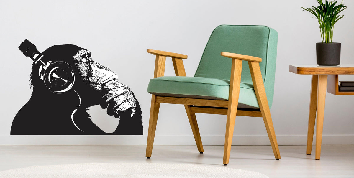 Vinyl wall decal of a contemplative monkey wearing headphones, adding a cool vibe to any room.