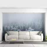 Misty Pine Hill wall mural creating a serene forest ambiance behind a modern white couch in a stylish living room.