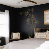 Gold floral line art wall decal in a modern black bedroom, adding elegance and style to the corner space.
