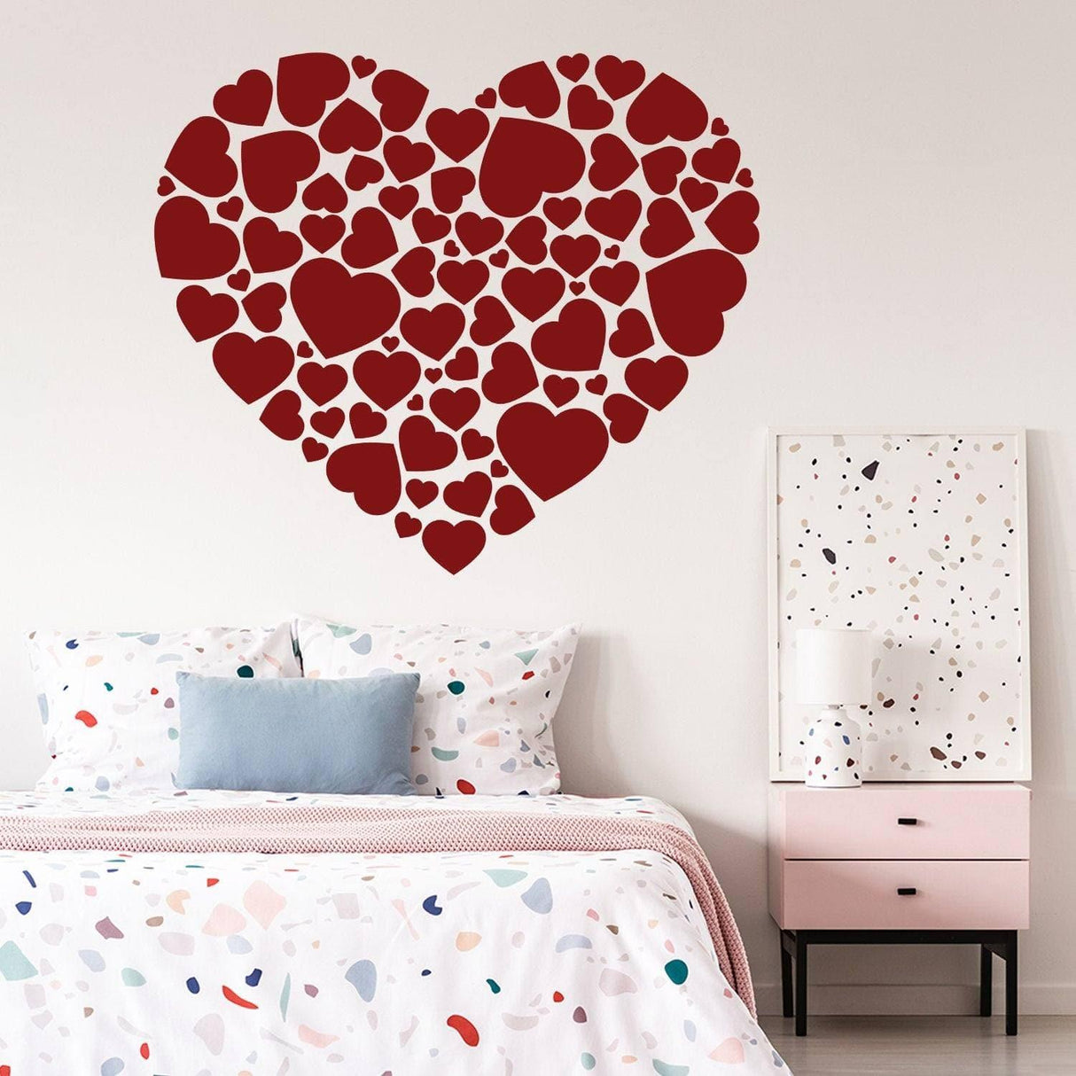 Red heart-shaped vinyl sticker collage on a wall.