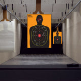 Silhouette scoring target sheets displayed in a designated practice setting.