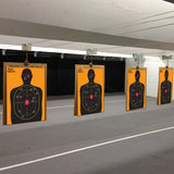 Set of full-length silhouette scoring target sheets displayed indoors.