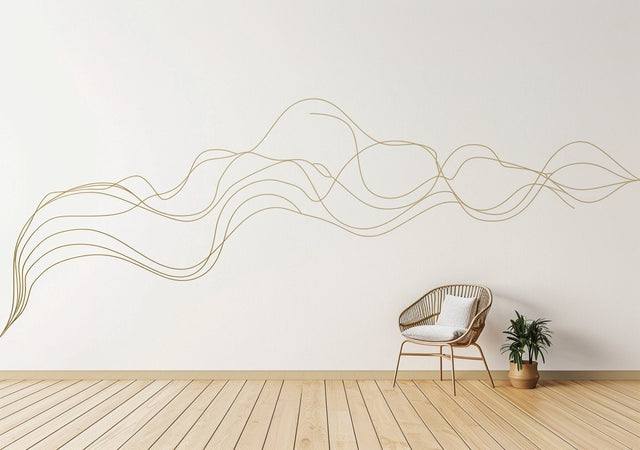 A large, abstract gold swirl line decal flows across a white wall in a minimal modern interior.