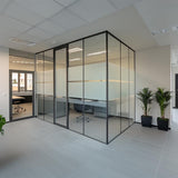 Modern office with frosted glass partitions providing privacy and natural light to workspaces.