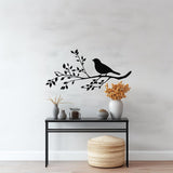 Elegant bird silhouette on branch wall decal above a styled modern table with decorative vases.