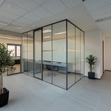 Modern office space with frosted glass partitions enhancing privacy and light usability.