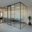 Modern office with glass partitions featuring frosted sections for privacy and natural light.