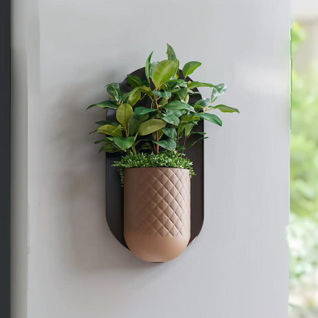Textured 3D printed wall planter with a concealed mounting form and small indoor plant.