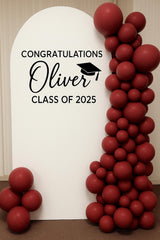 Graduation backdrop example with a personalized name and year beside balloons.