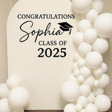 Personalized name and year graduation decal on a balloon arch backdrop.