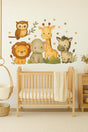 A nursery with a wooden crib and a large safari-themed wall decal featuring a lion, elephant, giraffe, zebra, and owl.