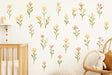 A nursery wall decorated with soft pastel flower decals in peach, blush, and yellow tones.
