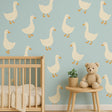 A nursery wall decorated with twelve large cream-colored goose decals, arranged evenly on a soft blue wall.
