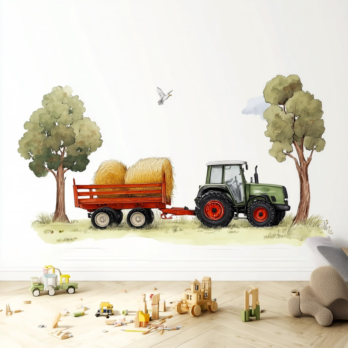 A playful wall decal featuring a green farm tractor pulling a trailer with hay bales between two trees.