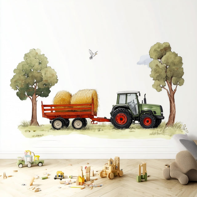 A playful wall decal featuring a green farm tractor pulling a trailer with hay bales between two trees.