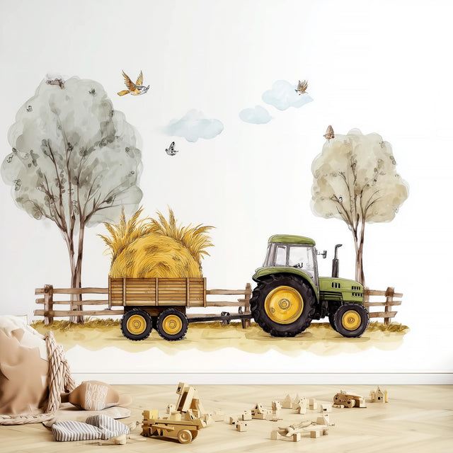 A farm-themed nursery wall decal showing a green tractor pulling a hay-loaded wooden trailer along a dirt path.