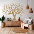 A large, leafless tree wall decal in a soft neutral tone, applied in a cozy, boho-style living room.