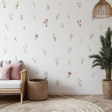 A bright and cozy nursery room decorated with individually spaced watercolor floral wall decals in soft shades of pink.