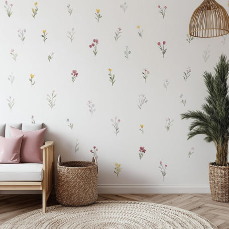 A bright and cozy nursery room decorated with individually spaced watercolor floral wall decals in soft shades of pink.