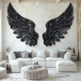 Large black angel wings wall decal applied to a living room wall above a white sectional couch.