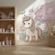 A cozy children’s room with a large wall decal of a pastel cartoon unicorn beside a fluffy pink tree.