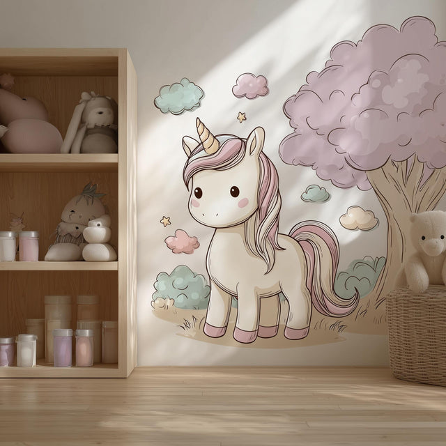 A cozy children’s room with a large wall decal of a pastel cartoon unicorn beside a fluffy pink tree.