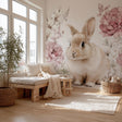 A cozy, sunlit nursery room with a giant wall decal of a fluffy light brown bunny.