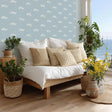 A serene coastal bedroom with white ocean wave decals scattered across a soft blue wall.