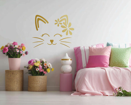 Wall decal of a simple cat face with closed eyes, whiskers, and a floral design on one ear.