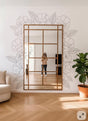 Vinyl wall decals of outline flowers and leaves arranged around a large rectangular mirror in a modern living room.